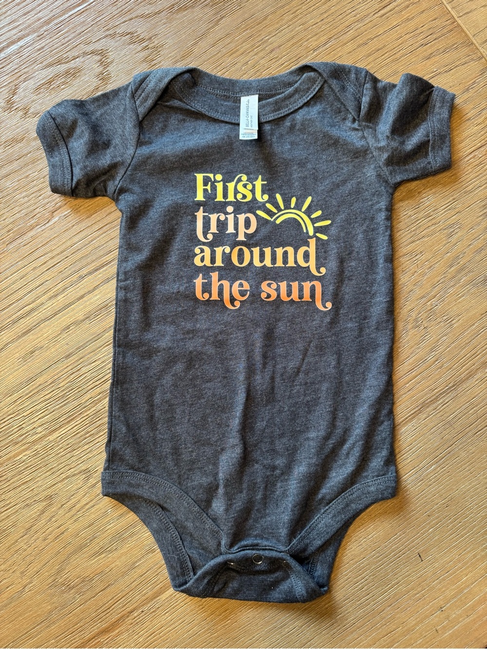 Bella Canvas Charcoal Baby One-Piece with Yellow and Orange Sun Graphic